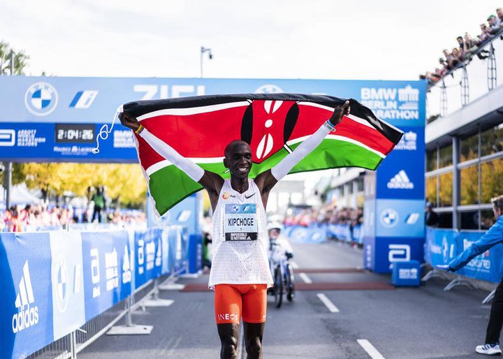 Eliud Kipchoge celebrates with the Kenyan flag set a new world marathon record in Berlin on September 25, 2022