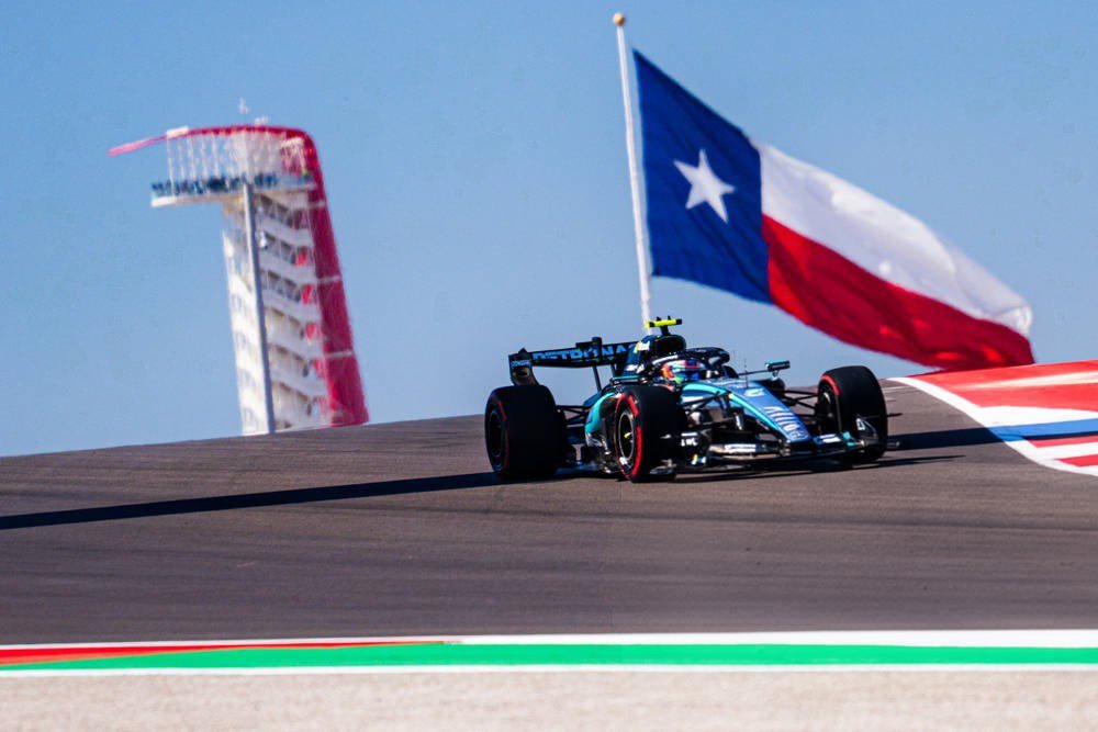 Kimi Antonelli in a Mercedes F1 car on track at the Circuit of the Americas, with a Texas flag and the tower behind