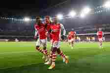 Eddie Nketiah of Arsenal (R) celebrates with teammates Rob Holding and Folarin Balogun of Arsenal after scoring their team's first goal during the ...