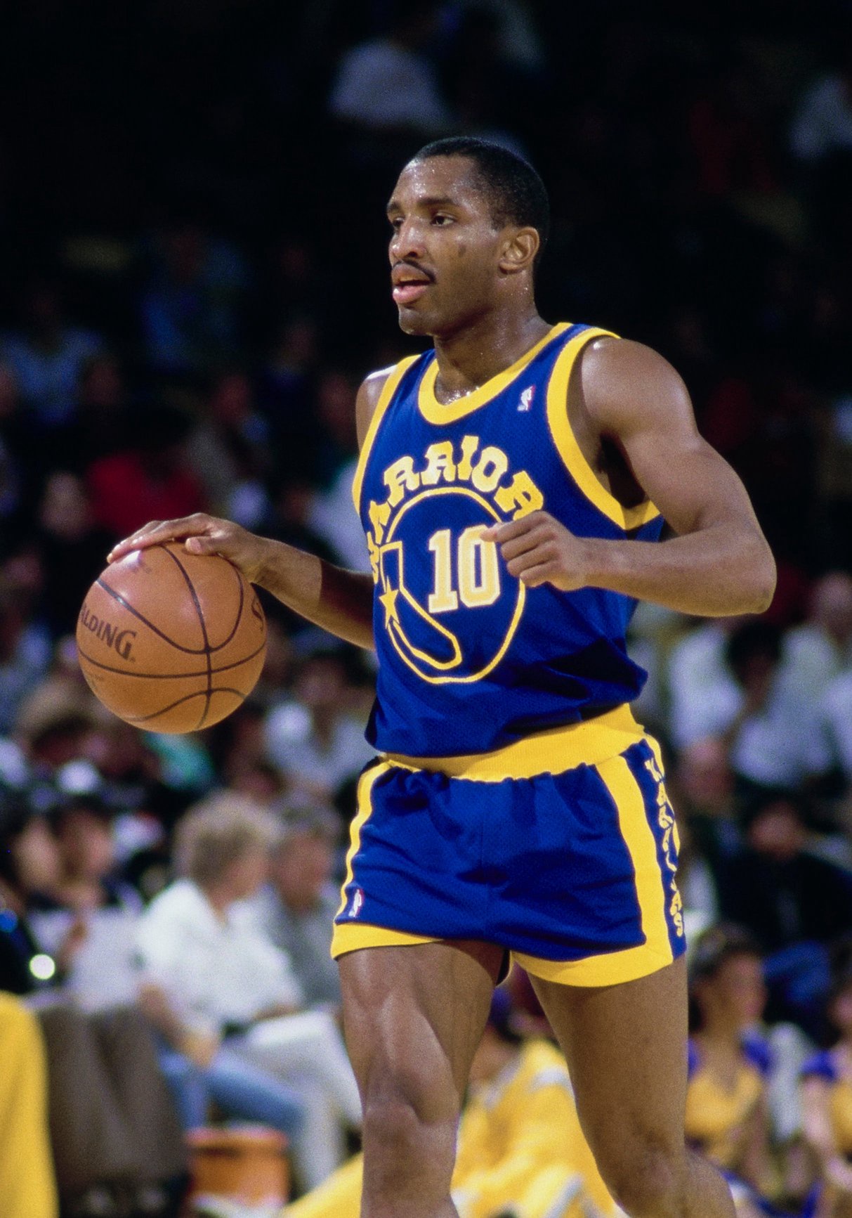 Perry Moss #10, Point Guard for the Golden State Warriors in motion dribbling the basketball down court during their NBA Pacific Division basketball game against the Los Angeles Lakers on 15th January 1987 at the The Forum arena in Inglewood, Los Angeles, California, United States. The Lakers won the game 129 - 109. (Photo by Rick Stewart/Allsport/Getty Images)