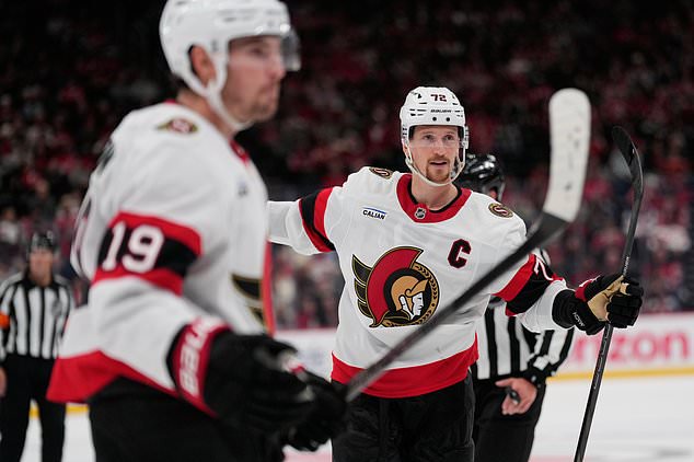 Ottawa Senators' Thomas Chabot, right, celebrates a goal by teammate Tim Stützle during the third period of an NHL hockey game against the New Jersey Devils in Newark, N.J., Monday, Oct. 12, 2026. (AP Photo/Seth Wenig)