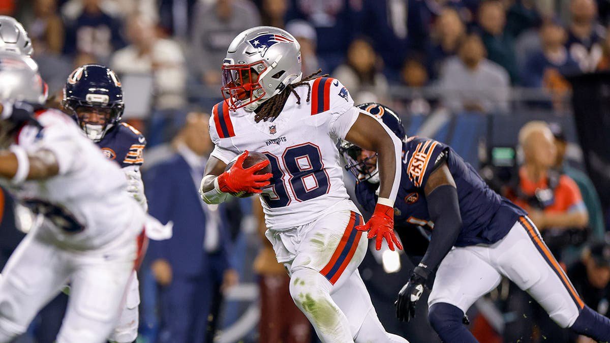 Rhamondre Stevenson runs with the ball during a game at Soldier Field.