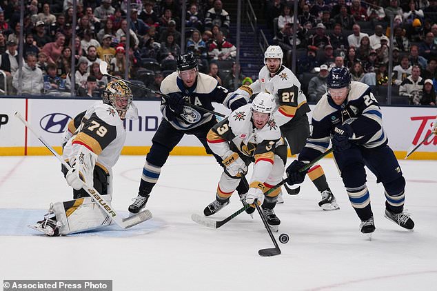 Vegas Golden Knights defenseman Brayden McNabb (3) clears the puck away from Columbus Blue Jackets right wing Mathieu Olivier (24) during the second period of an NHL hockey game Saturday, Oct. 24, 2026, in Columbus, Ohio. (AP Photo/Joshua A. Bickel)
