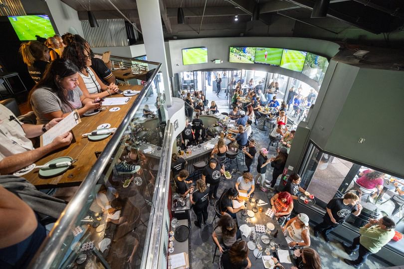 Patrons fill the bar, ordering food and drinks and watching women's sports during the grand opening of Watch Me! Sports Bar in Long Beach Friday, July 26, 2024