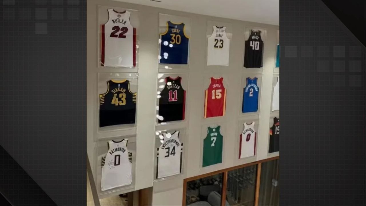 Parede com doze camisas de basquete emolduradas, incluindo Butler 22, Curry 30 e James 23