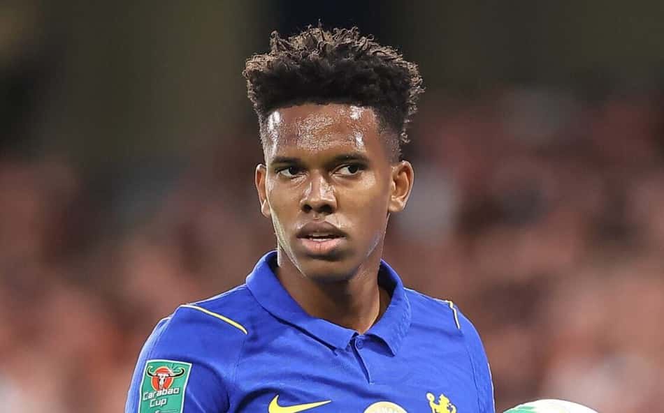 Estevão, jogador do Chelsea, com uniforme azul, segura a bola durante a partida.