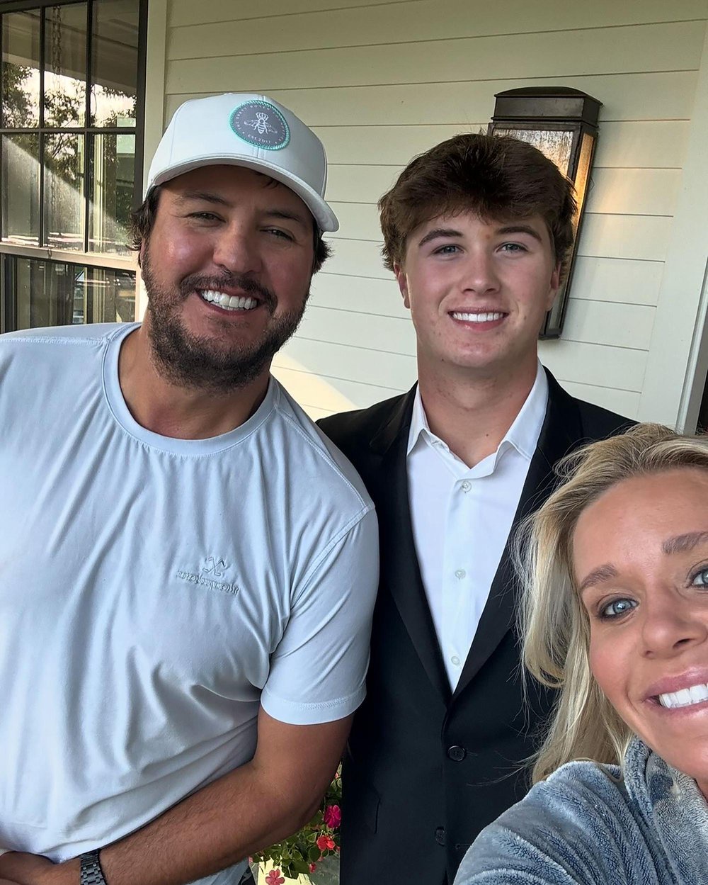 Luke Bryan, his wife Caroline, and their son Bo pose together for a smiling selfie.