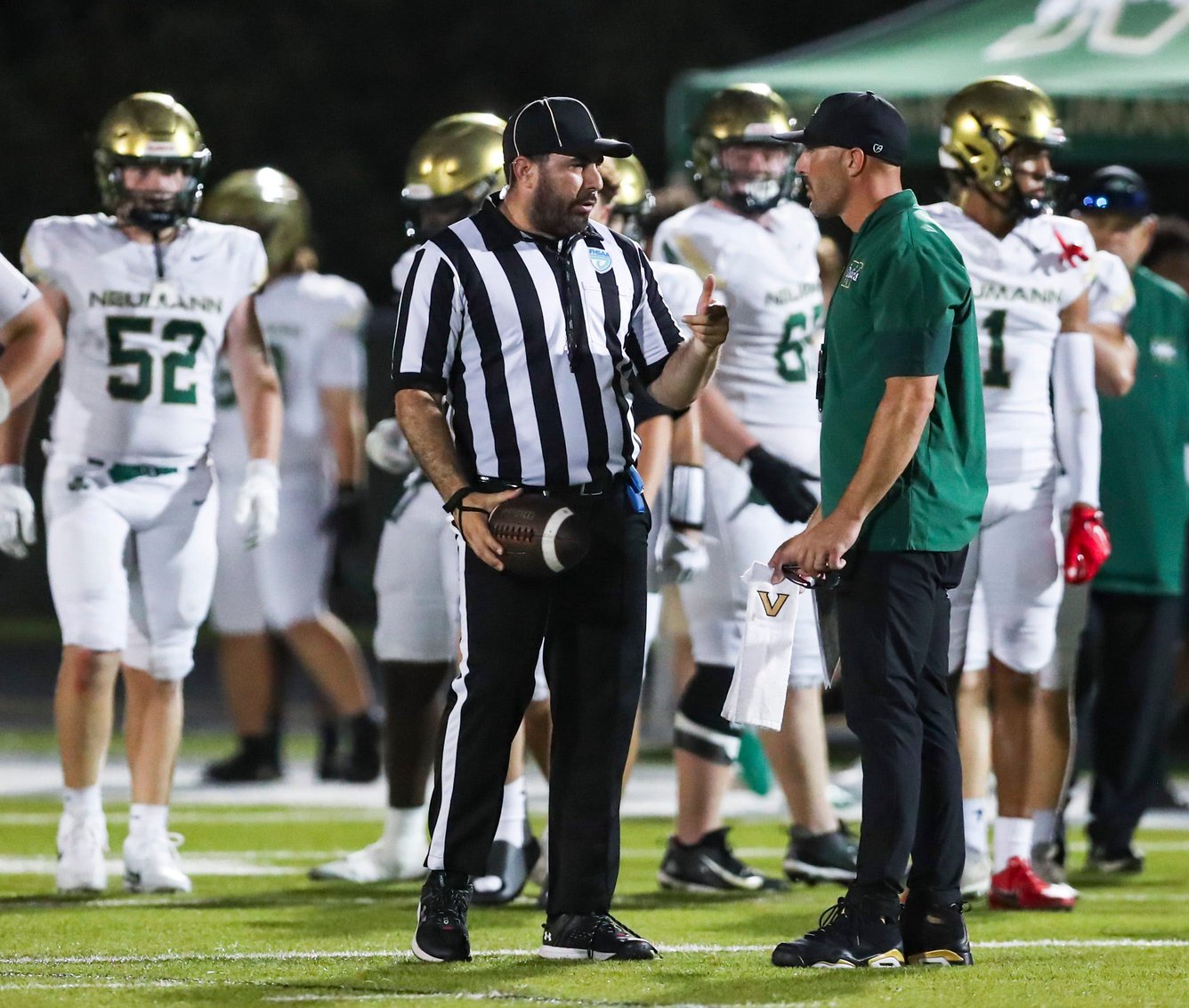 Referee Alex Acevedo explains a penalty call to Neumann Celtics head coach Chris Maragos during the second quarter of a district game against the First Baptist Academy Lions at First Baptist Academy in Naples, Fla., on Friday, Oct. 9, 2026.