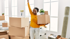 Woman smiling surrounded by moving boxes