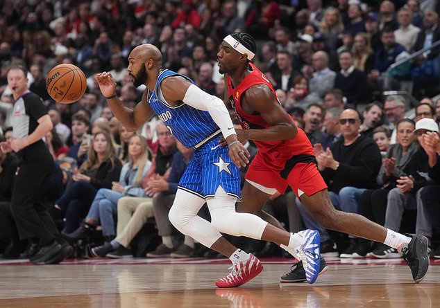 Orlando Magic's Jevon Carter, left, battles for the ball against Toronto Raptors' Ja'kobe Walter (14) during the first half of an NBA basketball game in Toronto, Wednesday, Oct. 28, 2026. (Nathan Denette/The Canadian Press via AP)