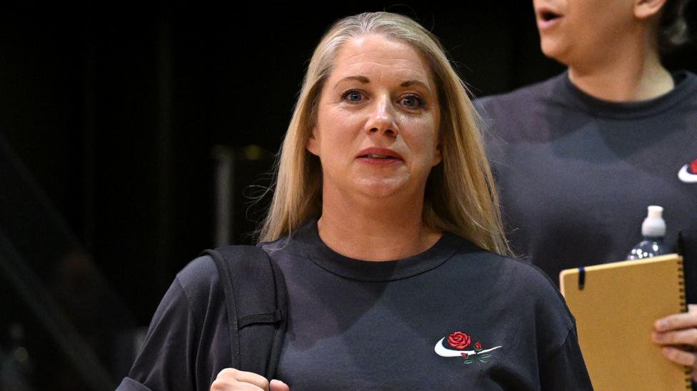 Anna Stembridge in dark blue England Roses T-shirt, with a bag over her right shoulder