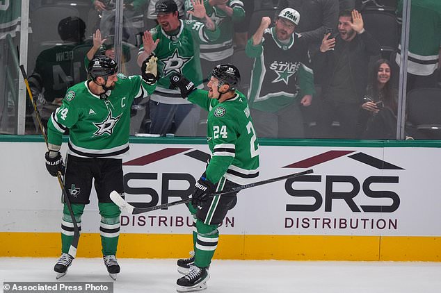 Dallas Stars center Roope Hintz (24) celebrates after scoring an overtime goal with teammate Jamie Benn, left, during an NHL hockey game against the Winnipeg Jets, Thursday, Oct. 22, 2026, in Dallas. (AP Photo/LM Otero)