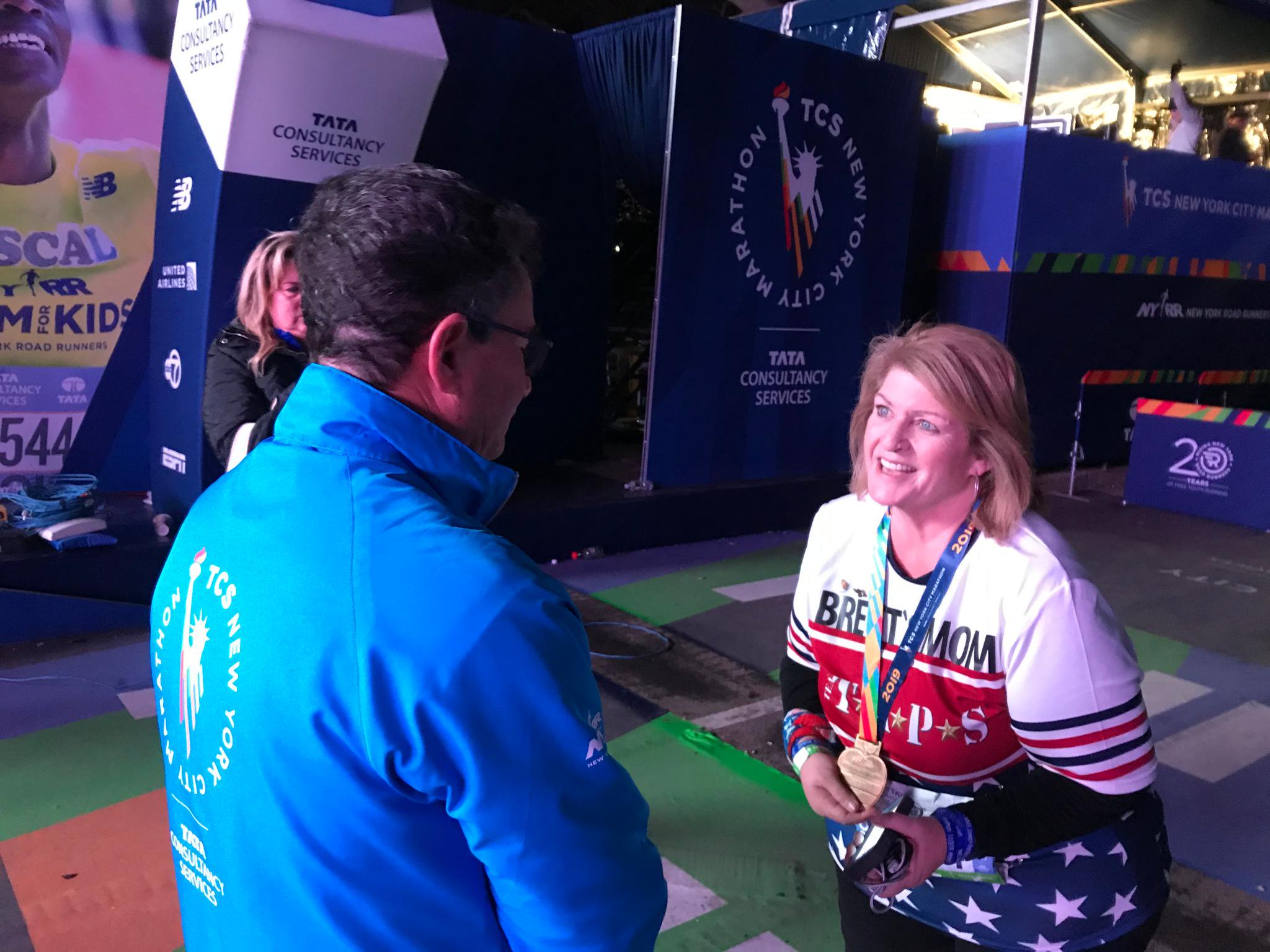 Shellie Warren smiling while wearing her marathon medal after finishing the New York City Marathon.