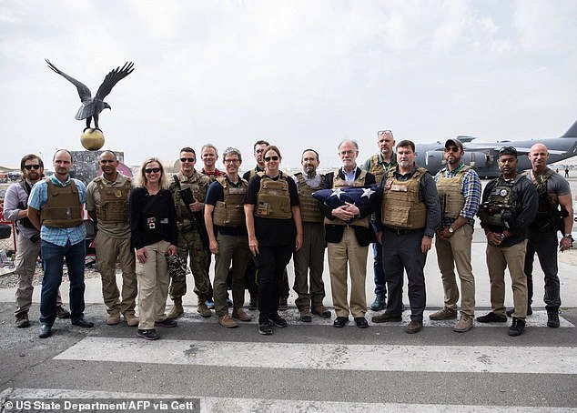This handout picture posted on the Twitter account of US Secretary of State Antony Blinken, August 31, 2021 shows Ambassador Ross Wilson (C) holding a US flag and poses with members of the US Embassy in Kabul, before they departed Afghanistan