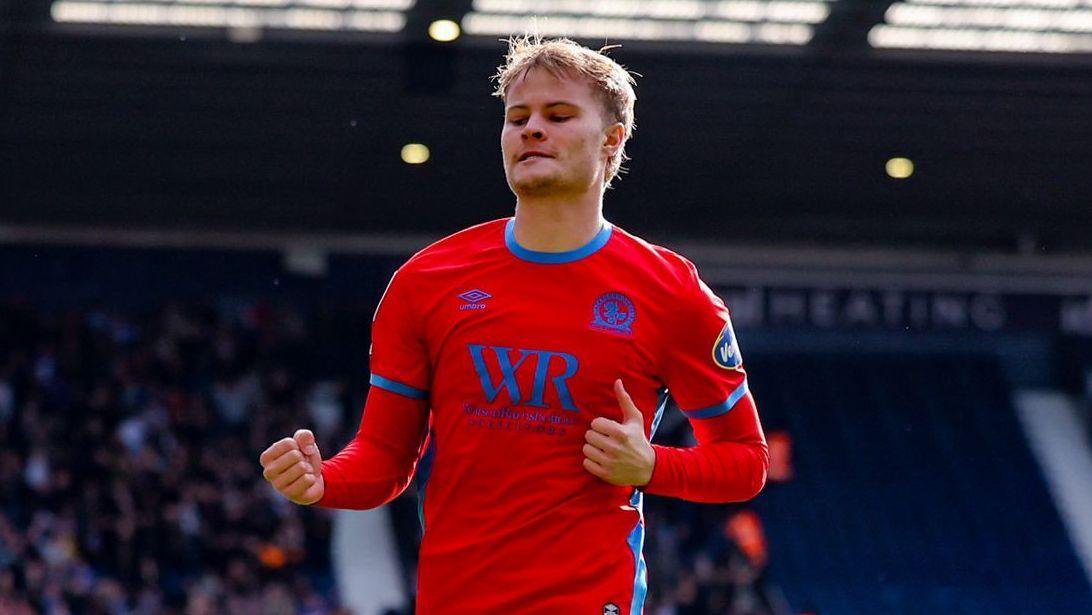 Andri Gudjohnsen in a red Blackburn away shirt clenches both fists to celebrate a goal