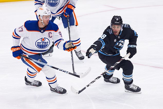 Utah Mammoth center Nick Schmaltz (8) stops the puck against Edmonton Oilers center Connor McDavid (97) during the first period of an NHL hockey game Saturday, Oct. 17, 2026, in Salt Lake City. (AP Photo/Melissa Majchrzak)