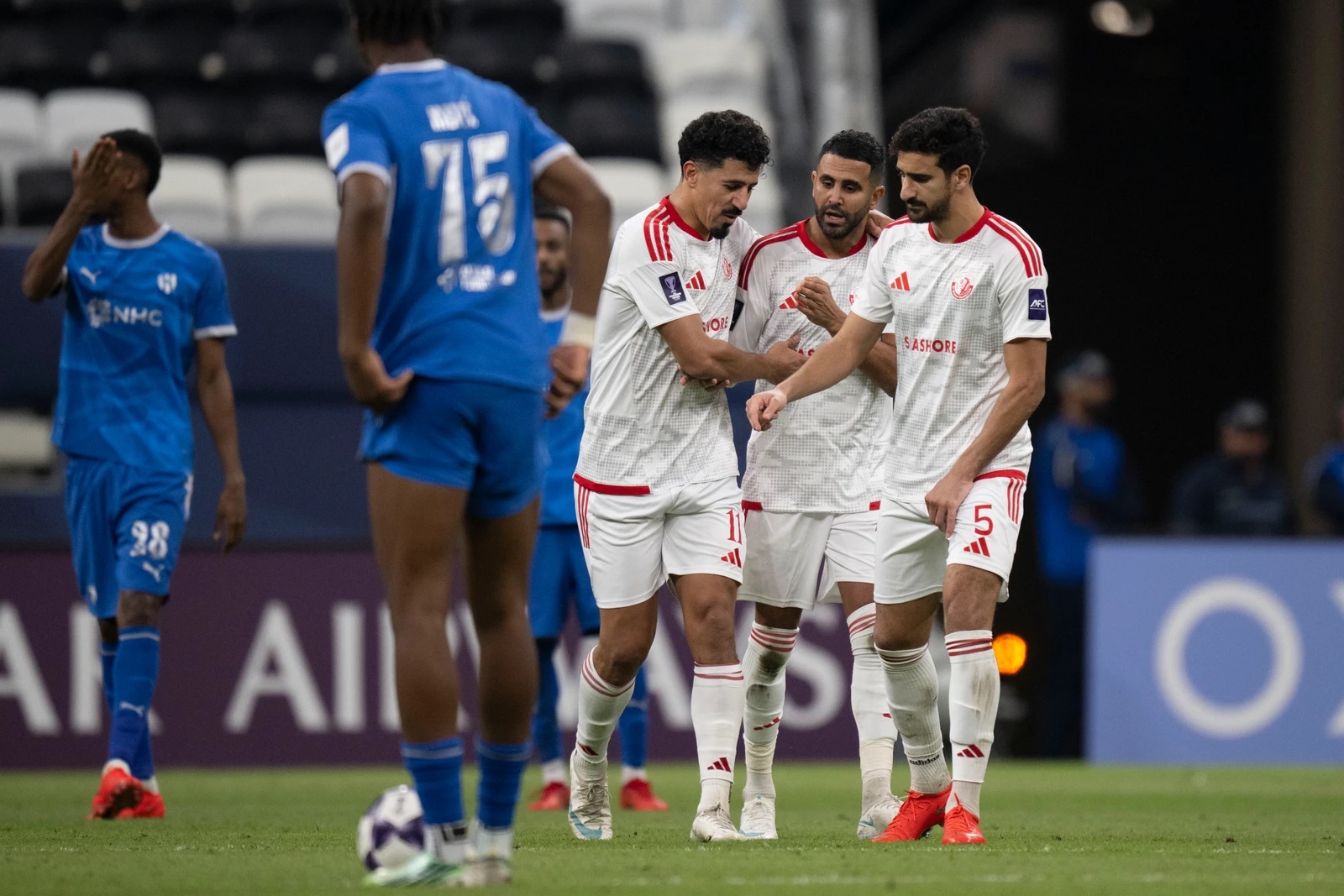 Baghdad Bounedjah, Riyad Mahrez and Mohamed Ali Ben Romdhane embrace as Al-Shamal take a 3-1 lead over Al-Hilal. (AFC)