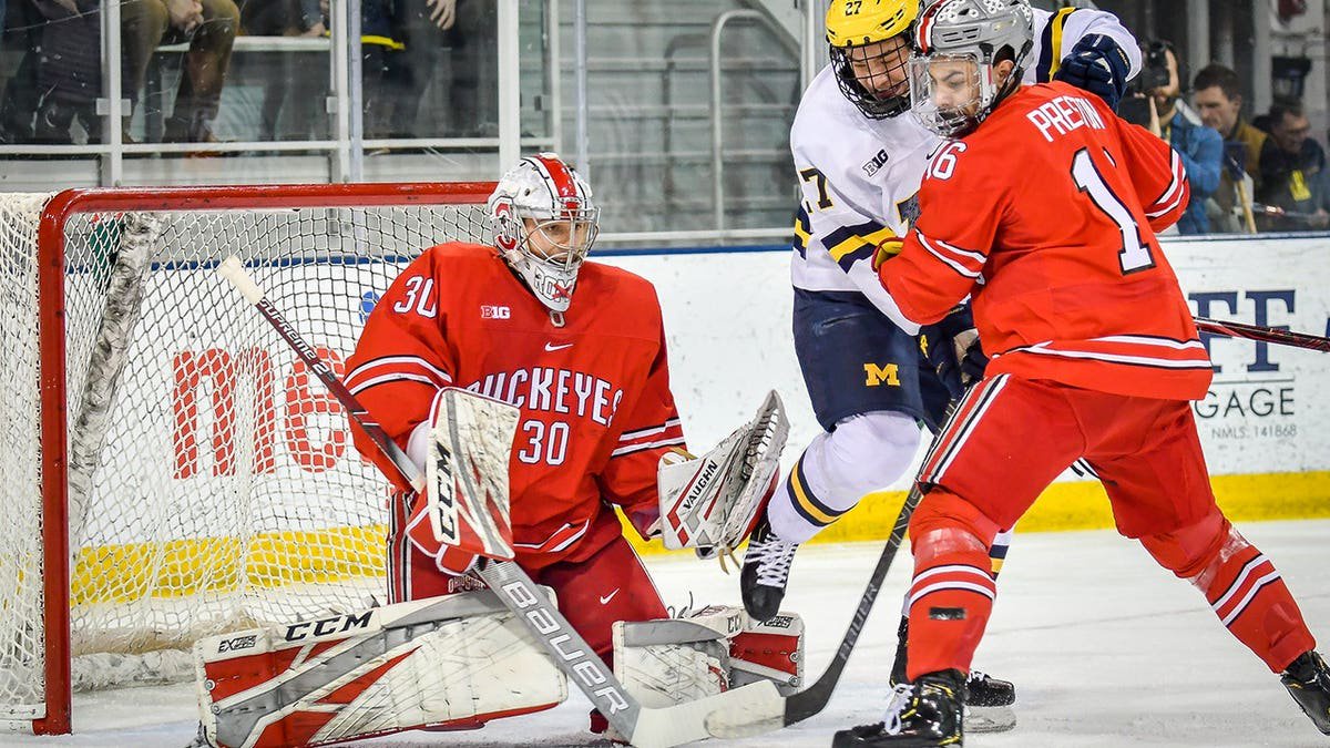 Sean Romeo guards the goal as Nolan Moyle screens in front during a hockey game.
