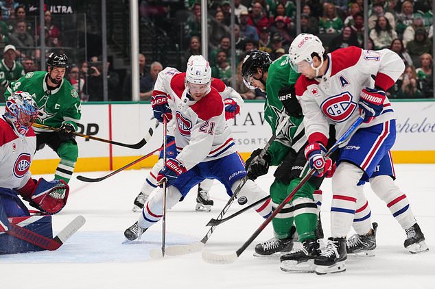 Montréal Canadiens' Kaiden Guhle (21) and Josh Anderson (17) help defend against pressure at the net by Dallas Stars' Wyatt Johnston, second from right, during the first period of an NHL hockey game in Dallas, Thursday Oct. 29, 2026. (AP Photo/Tony Gutierrez)