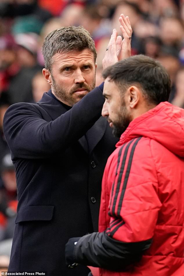 Manchester United's head coach Michael Carrick applauds to supporters as Manchester United's Bruno Fernandes passes ahead of the start of the English Premier League soccer match between Manchester United and Bournemouth in Manchester, England, Sunday, Oct. 25, 2026. (AP Photo/Dave Thompson)