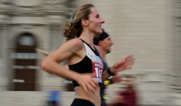 A runner smiles as she runs past the Cathedral of St. Paul in a blur.