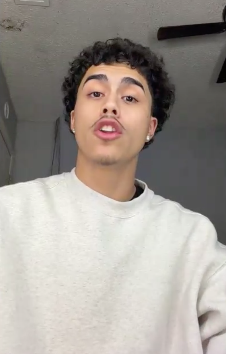 Noah Reyes wearing a white sweatshirt indoors.