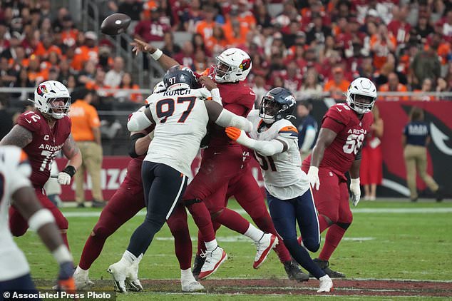 Arizona Cardinals quarterback Jacoby Brissett (7) is hit by Denver Broncos defensive tackle Malcolm Roach (97) and linebacker Que Robinson (51) during the second half of an NFL football game in Glendale, Ariz., Sunday, Oct. 25, 2026. (AP Photo/Rick Scuteri)