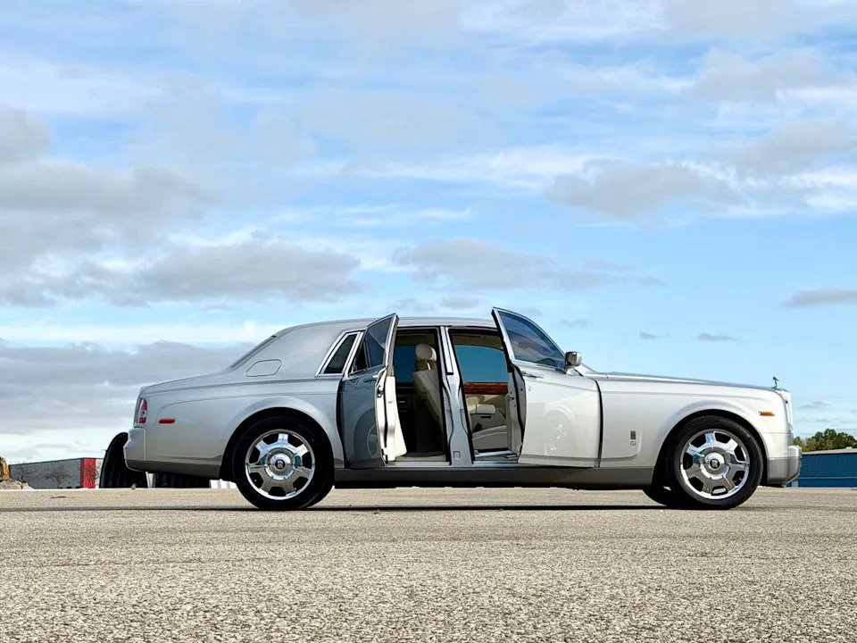 side view, silver luxury sedan parked with both passenger-side doors open.