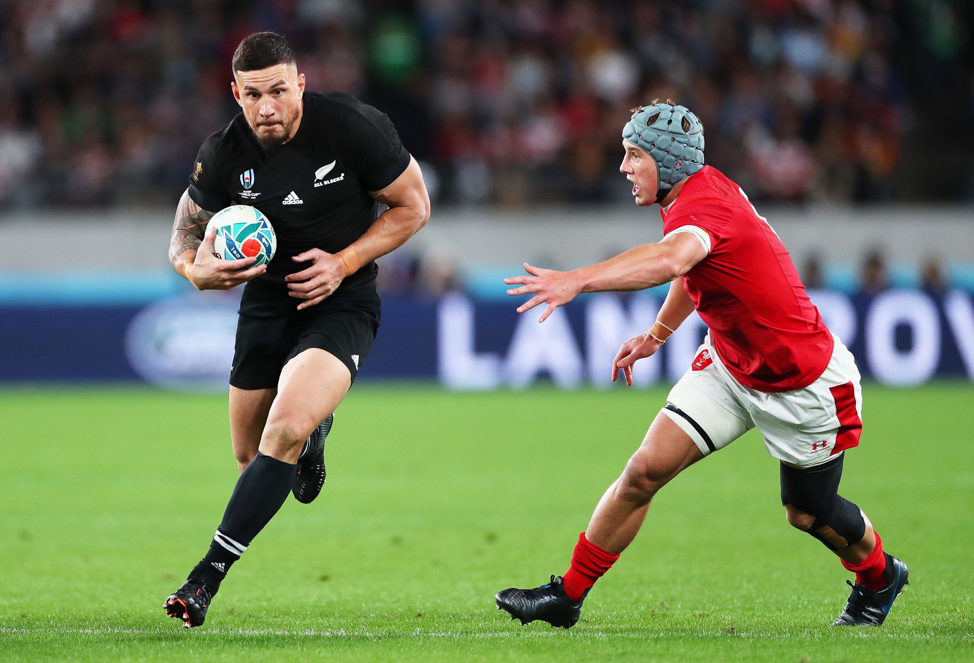 New Zealand's Sonny Bill Williams runs past Wales' Jonathan Davies during the 2019 Rugby World Cup Bronze Final match