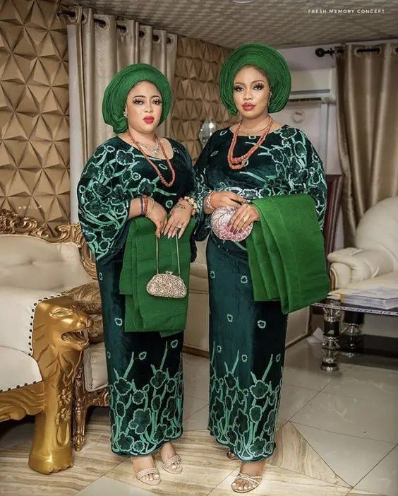 Two beautiful women dressed in green iro and buba as African traditional dresses