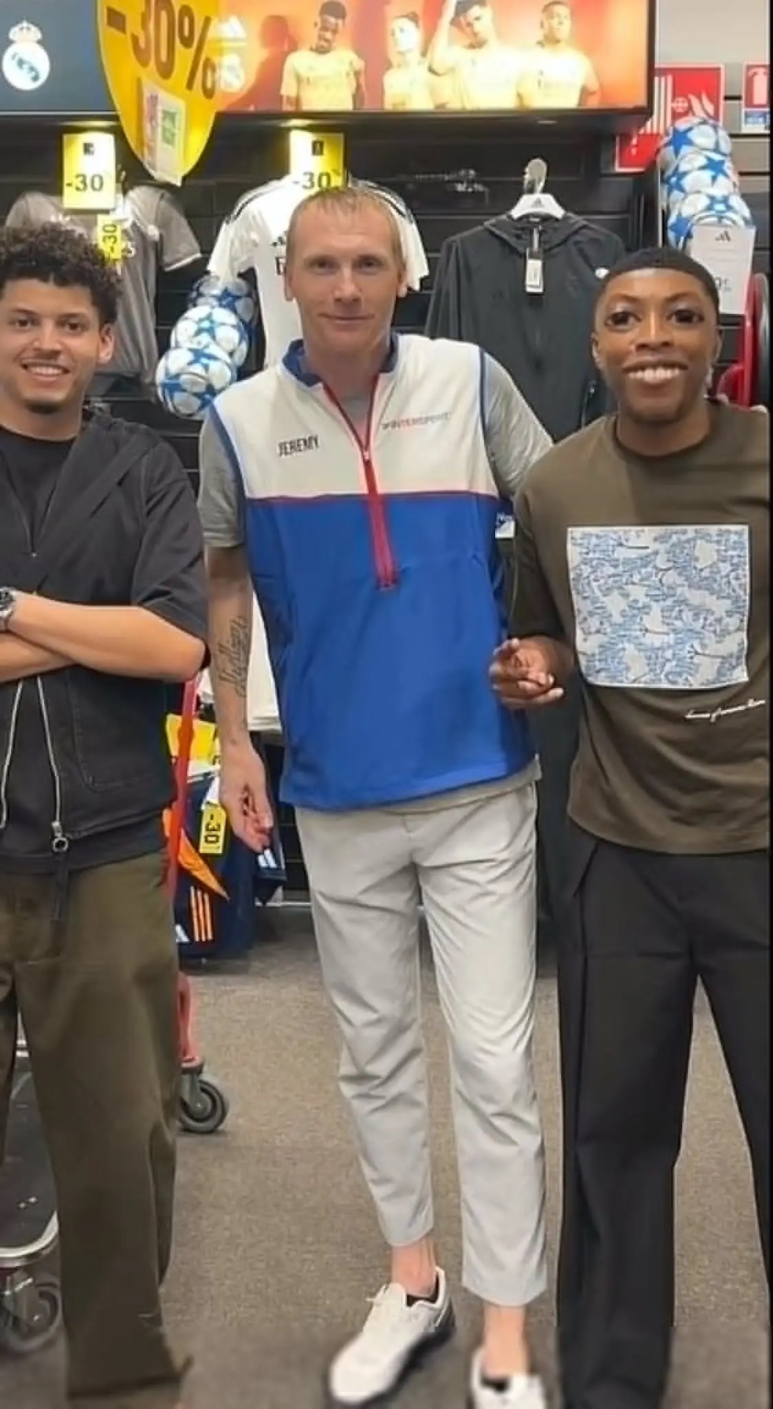 Jeremy Mathieu poses with two fans in a sports shop. Image: X@BarcaUniversal