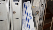 A mail-in election ballot is positioned in the mailbox