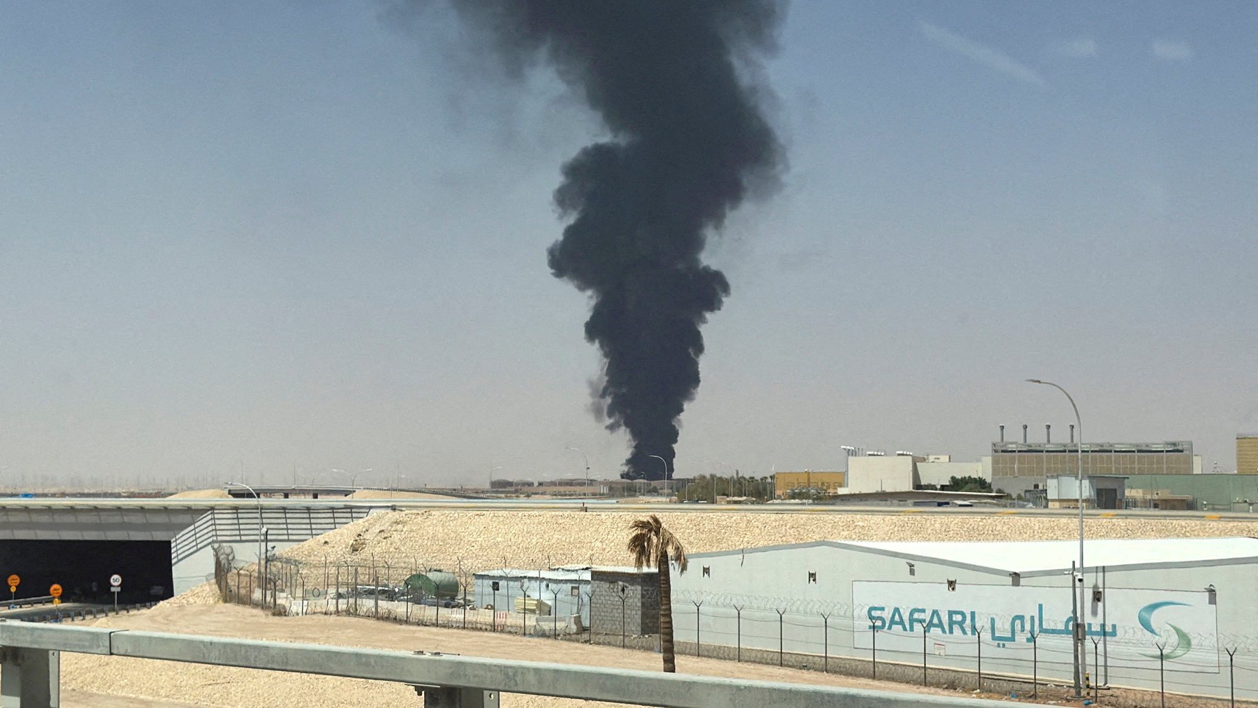 A large plume of black smoke rises from the fuel storage area at King Khalid International Airport