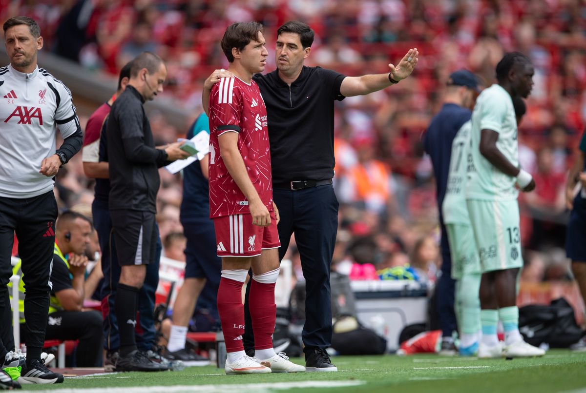 Liverpool head coach Andoni Iraola speaks with Federico Chiesa on the Anfield touchline.