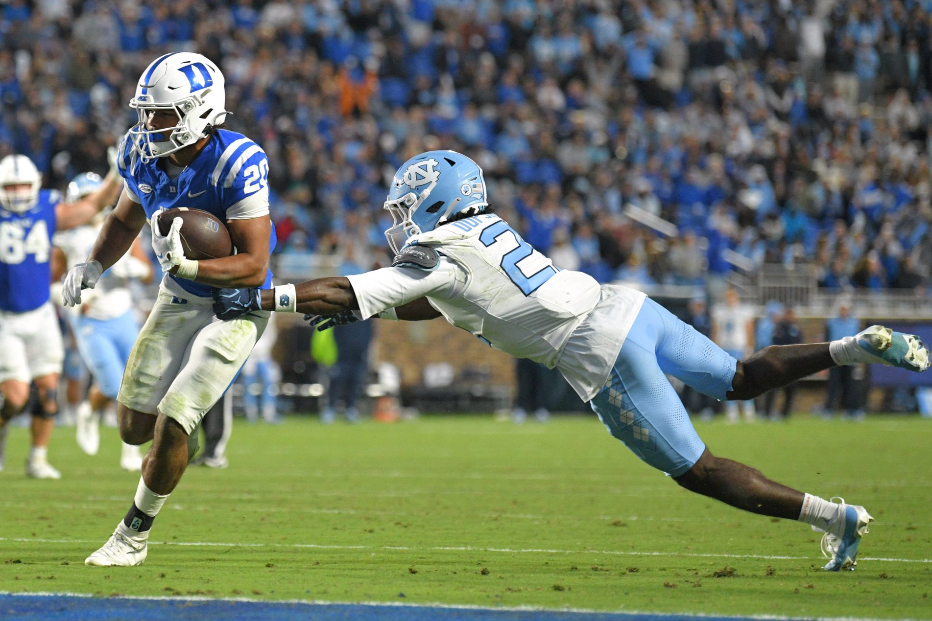 Oct 17, 2026; Durham, North Carolina, USA;  Duke Blue Devils running back Nate Sheppard (20) runs the ball against North Carolina Tar Heels defensive back Kenton Dopson III (21) during the fourth quarter at Wallace Wade Stadium.  Mandatory Credit: Zachary Taft-Imagn Images