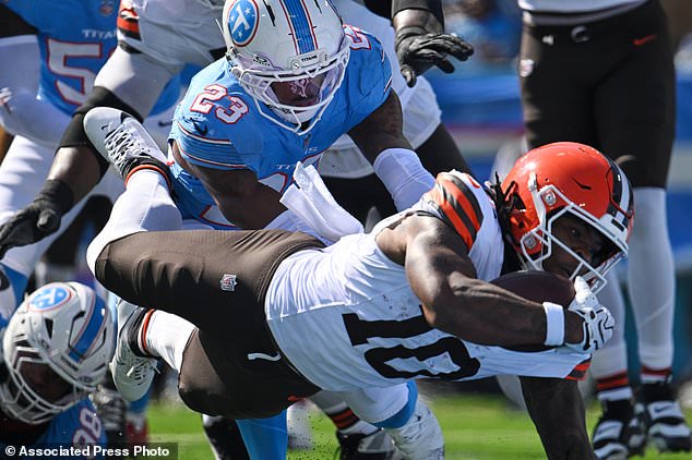 Cleveland Browns running back Quinshon Judkins (10) dives past Tennessee Titans safety Kevin Winston Jr. (23) and defensive tackle Jeffery Simmons (98) to score a touchdown during the first half of an NFL football game in Nashville, Tenn., Sunday, Oct. 25, 2026. (AP Photo/John Amis)