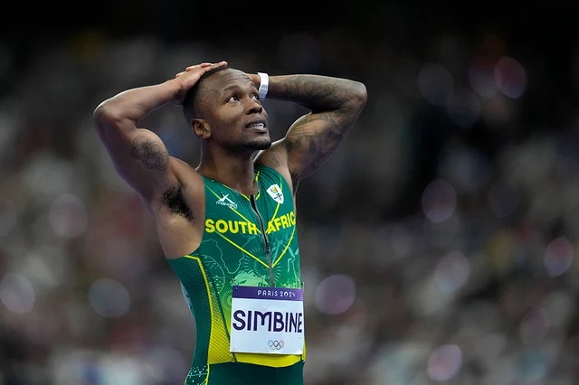 Akani Simbine reacts after crossing the finish line