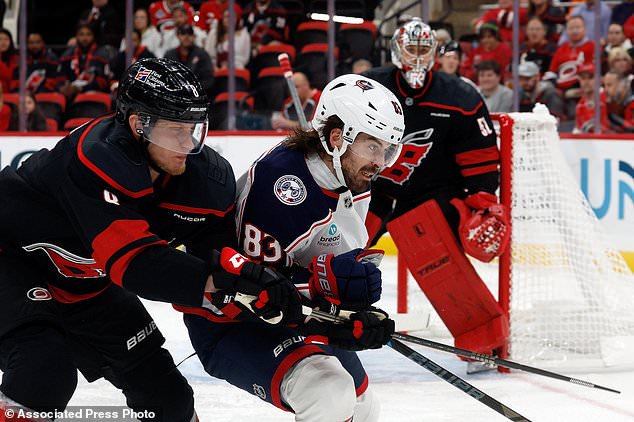 Carolina Hurricanes' Juuso Välimäki (8) collides with Columbus Blue Jackets' Conor Garland (83) during the first period of an NHL hockey game in Raleigh, N.C., Thursday, Oct. 29, 2026. (AP Photo/Karl DeBlaker)