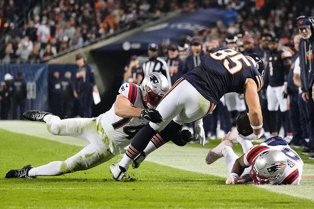 Chicago Bears tight end Cole Kmet (85) catches a pass and is tackled by New England Patriots' Robert Spillane (14) and Christian Gonzalez, right, during the second half of an NFL football game in Chicago, Thursday, Oct. 22, 2026. (AP Photo/Nam Y. Huh)