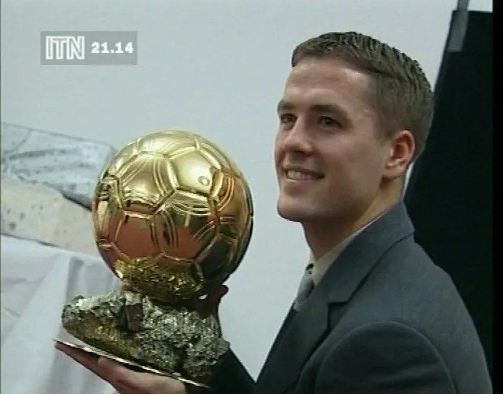 Michael Owen holding the Ballon D'Or trophy.