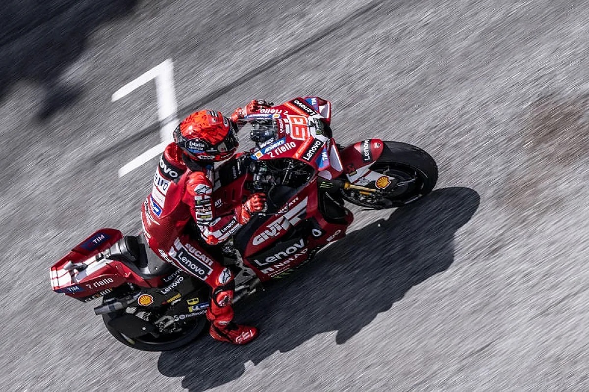 A rider in red Ducati leathers and helmet, number 93 on the bike, leaning through a corner on a MotoGP Ducati Desmosedici at Sepang.