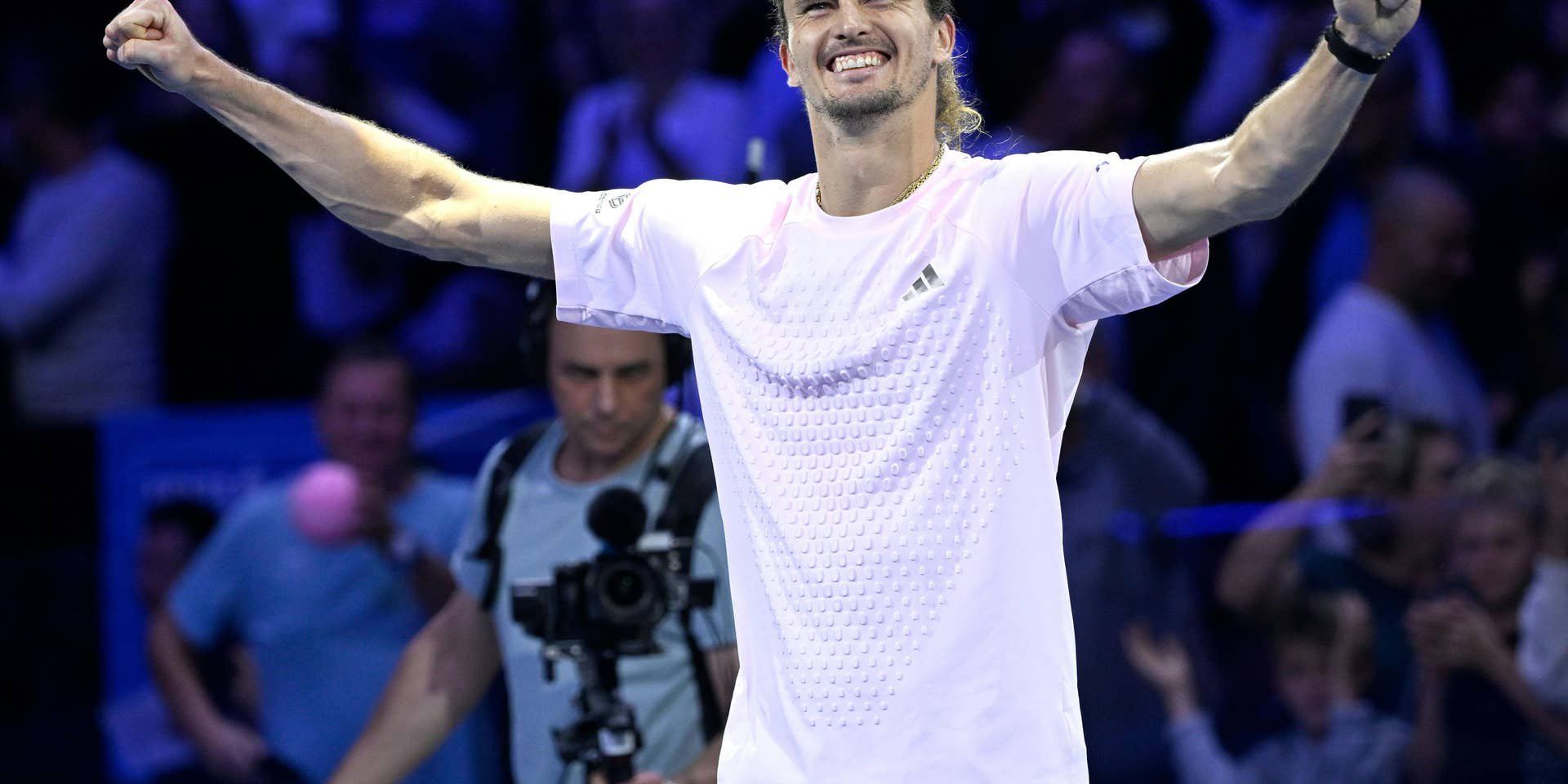 Alexander Zverev jubelt mit erhobenen Armen auf einem Tennisplatz, Zuschauer im Hintergrund.