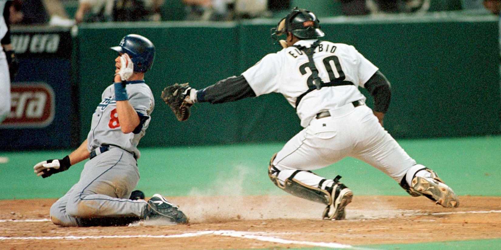 Los Angeles Dodgers Mark Grudzielanek (R) slides safely by Houston Astros catcher Tony Eusebio during the third inning at the Astrodome.