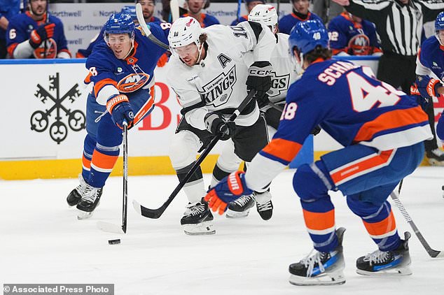 New York Islanders' Logan Stanley (8) fights for control of the puck with -Los Angeles Kings' Artemi Panarin (10) during the first period of an NHL hockey game Thursday, Oct. 22, 2026, in Elmont, N.Y. (AP Photo/Frank Franklin II)