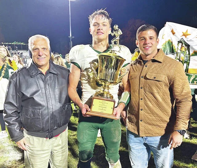 <p>Wyoming Area Warrior Luke Kopetchny was given the 2026 Carmelo Falcone MVP Memorial Award by Carmen Falcone, left, and Samuel Falcone, right, representing the Falcone family at the end of the cross-town rival game between Pittston Area and Wyoming Area on Friday night at Charley Trippi Stadium.</p>
                                 <p>Tony Callaio | For Times Leader</p>