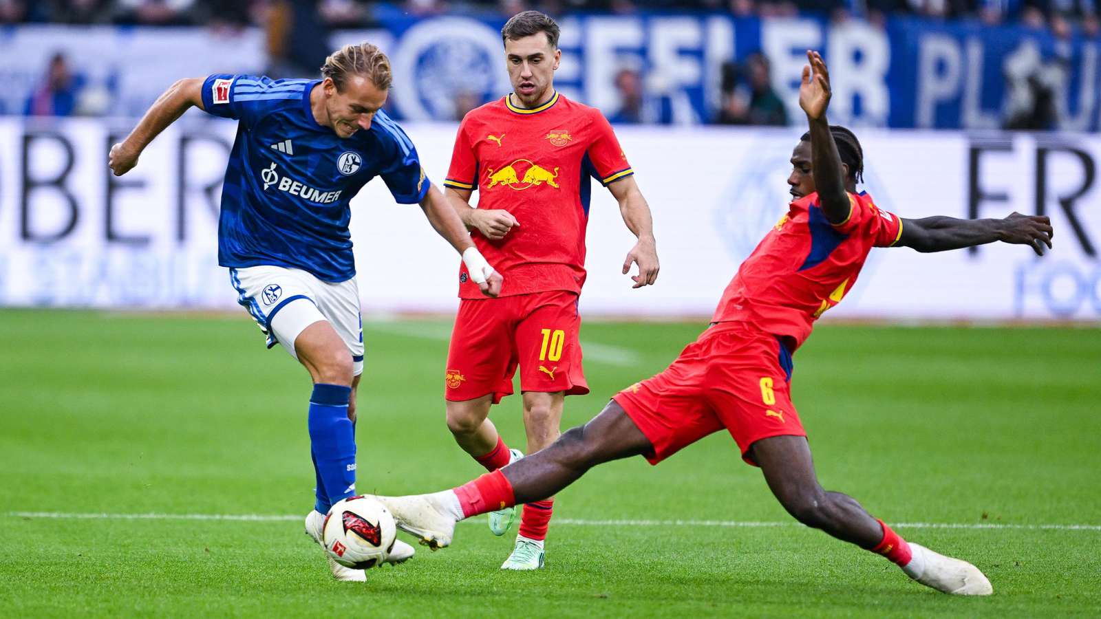 Timo Becker vom FC Schalke 04 im Zweikampf gegen zwei Leipziger. 