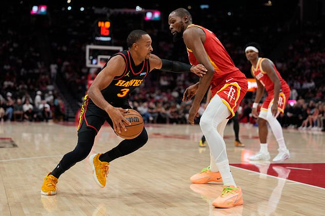 Atlanta Hawks guard CJ McCollum (3) is defended by Houston Rockets forward Kevin Durant, front right, during the first quarter of an NBA basketball game Monday, Oct. 26, 2026, in Houston. (AP Photo/Kevin M. Cox)