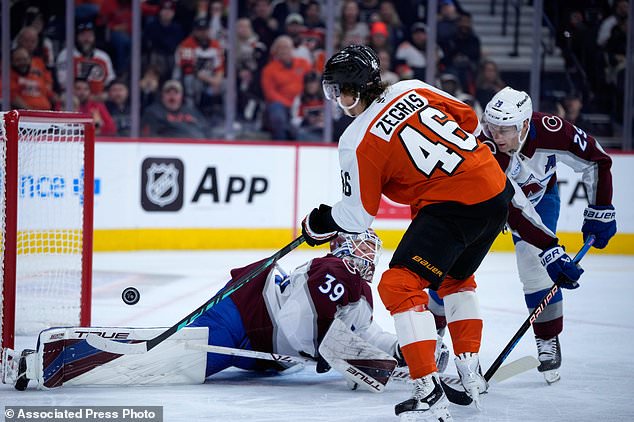 Philadelphia Flyers' Trevor Zegras (46) cannot get a shot past Colorado Avalanche's Mackenzie Blackwood (39) and Nathan MacKinnon (29) during the second period of an NHL hockey game Monday, Oct. 19, 2026, in Philadelphia. (AP Photo/Matt Slocum)