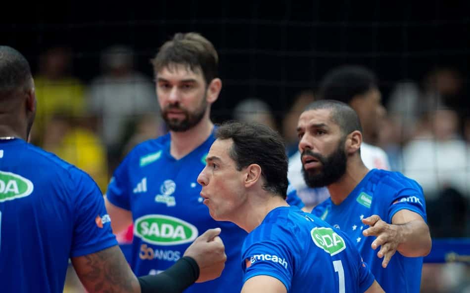 Jogadores do Cruzeiro Vôlei em uniforme azul celebram em quadra durante partida.