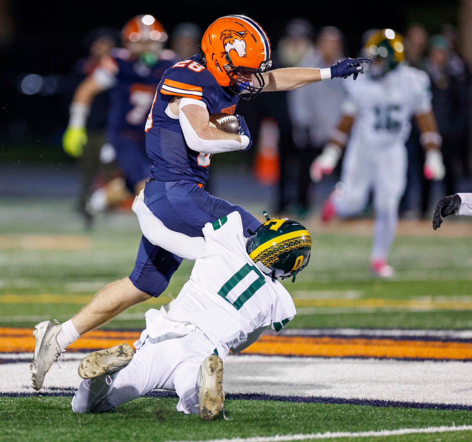 Naperville North's Jayke Collins (28) attempts to leap past Fremd's...